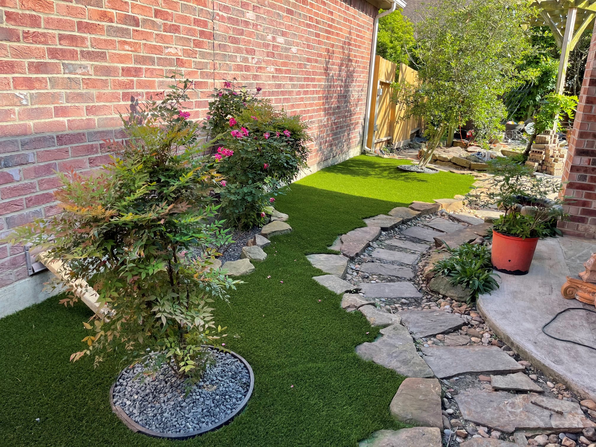 Artificial Grass In A Backyard, Complemented By A Neatly Arranged Stone Path