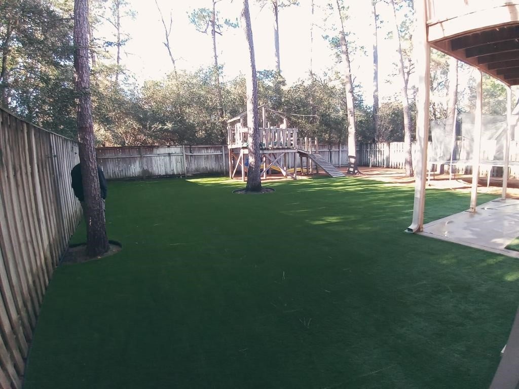Artificial Grass In A Backyard Surrounded By Trees