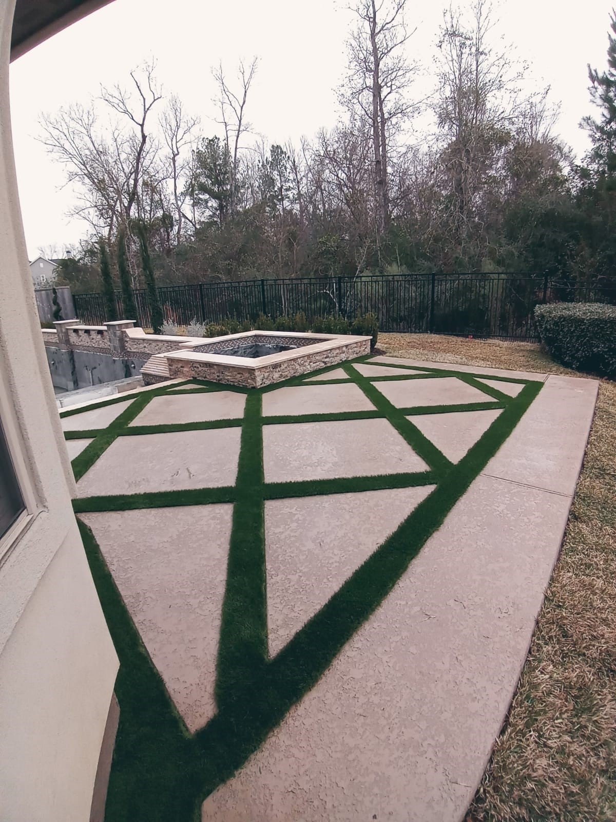 Artificial Grass Surrounds A Pool In A Well-maintained Backyard
