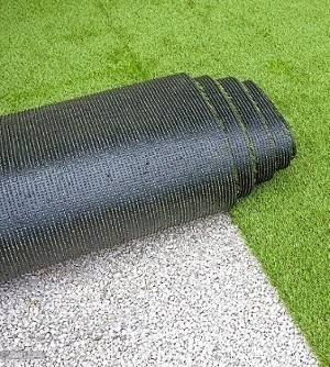 A Roll Of Artificial Grass Lies On The Ground