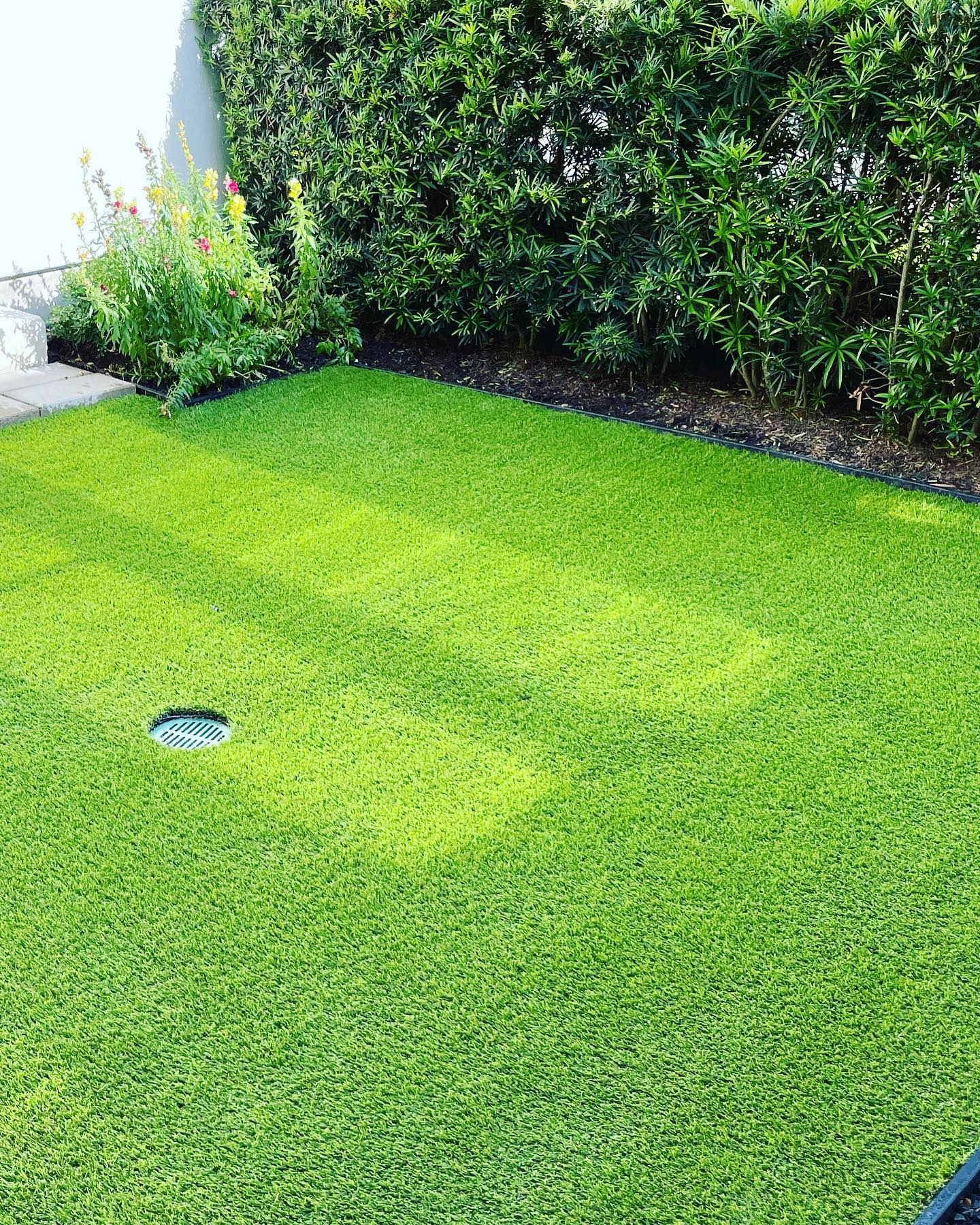 A Lush Expanse Of Artificial Grass Covering A Well-maintained Backyard